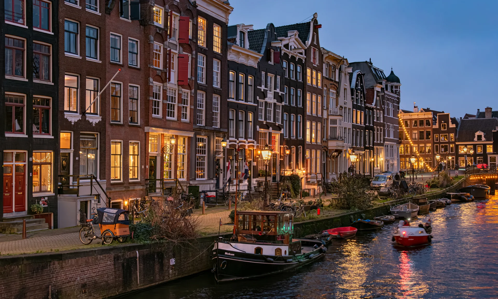 Amsterdam Brouwersgracht kanalında akşam ışıkları ve tarihi evler