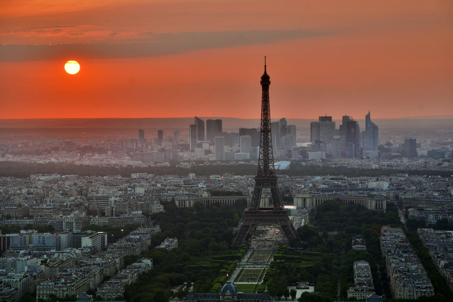 Gün batımında Eyfel Kulesi ve sıcak ışıkların altındaki Paris silüeti